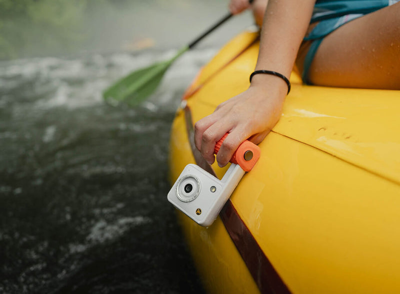 Hand gripping a white Portal AFN7 on the side of a yellow raft
