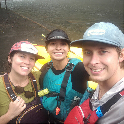 Three friends smiling in rafting gear